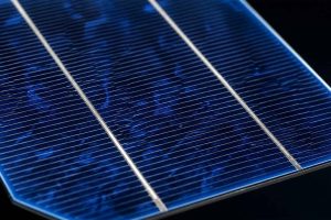 Gros plan d'une cellule photovoltaïque monocristalline en silicium bleu foncé, révélant les lignes conductrices métalliques et la texture cristalline. Comprendre le fonctionnement des panneaux solaires
